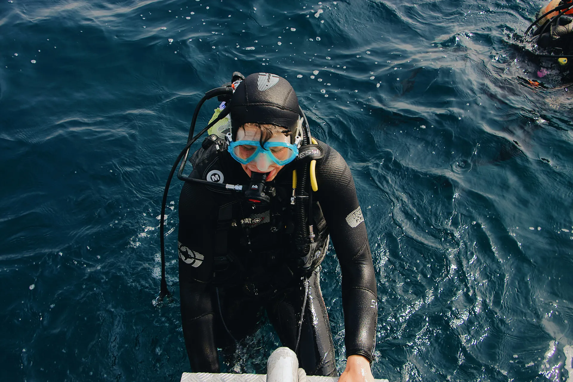 A scuba diver ascending a ladder after an ocean dive, capturing the essence of adventure.